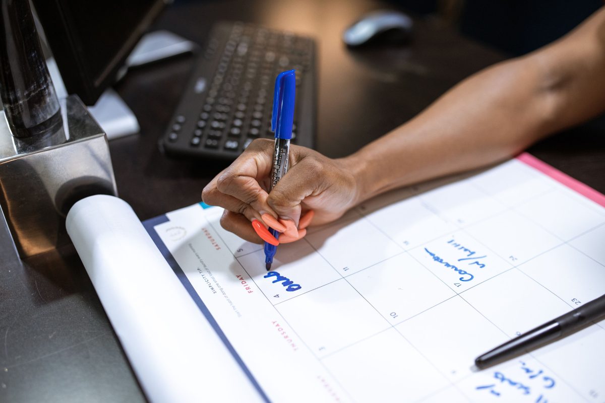 Hand writing an appointment on a monthly calendar