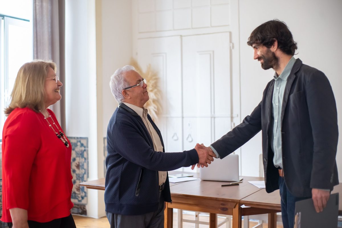 Smiling couple greeting their insurance advisor with a handshake